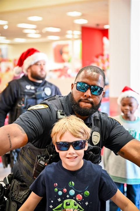 cop posing with child